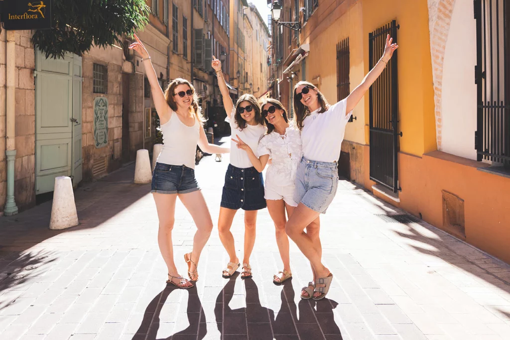 Groupe de filles colorées déambulant dans les ruelles typiques et étroites du Vieux-Nice pour un EVJF.