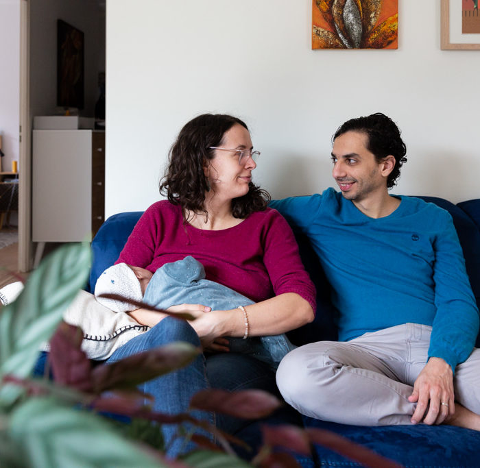 Couple assis sur un canapé avec leur bébé. Myriam Ohayon Photographe
