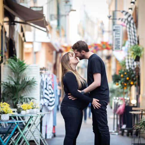 un couple dont la femme est enceinte pose dans les ruelles colorées du Vieux-Nice. Myriam Ohayon Photographe