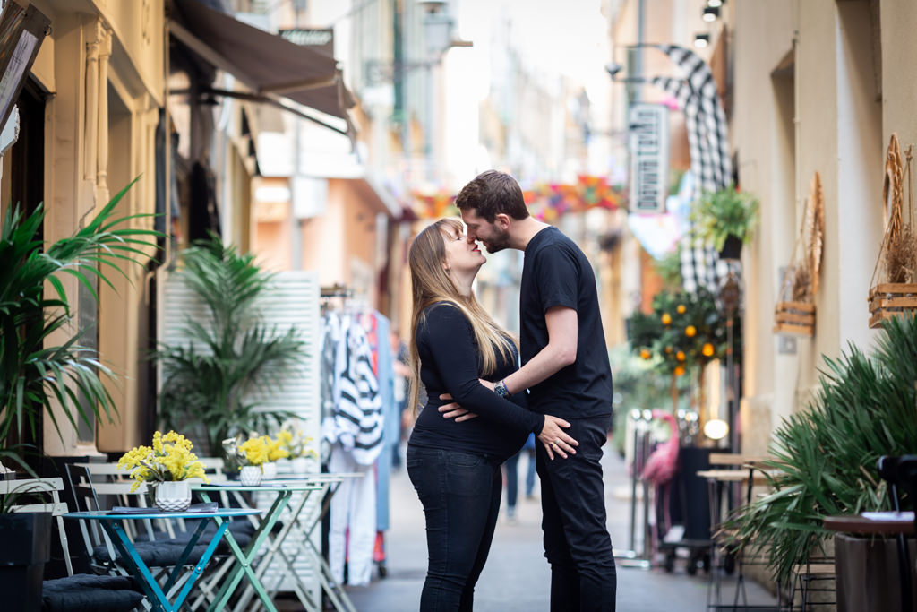 un couple dont la femme est enceinte pose dans les ruelles colorées du Vieux-Nice. Myriam Ohayon Photographe