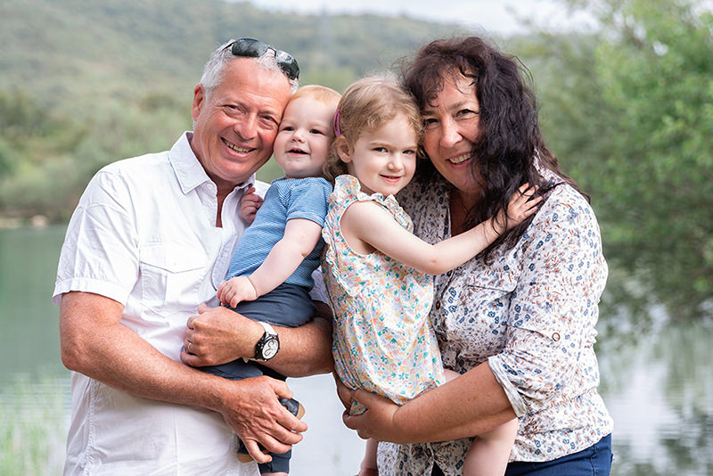 Séance photo famille lifestyle à Montauroux. Un grand père et une grand mère posent avec leurs petits enfants.