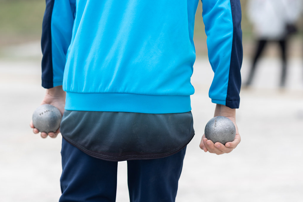 Photo de détail sur un joueur de pétanque tenant ses boules. Photo prise lors du championnat du Var - jeunes- le 19 mars 23 à Seillans