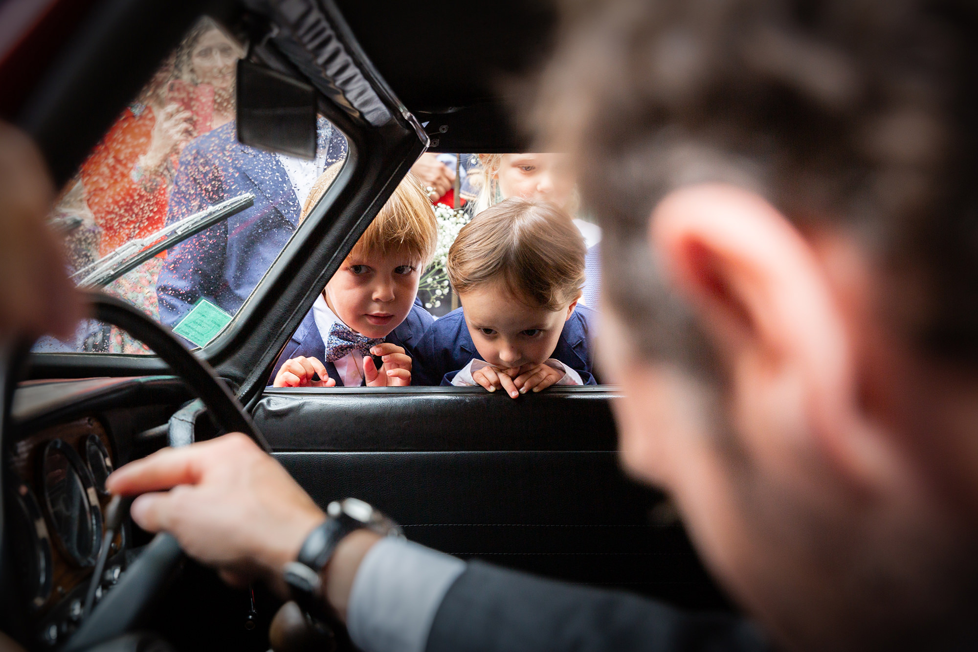 Des enfants regardent intrigués la voiture des mariés. Reportage documentaire de mariage dans le Var.