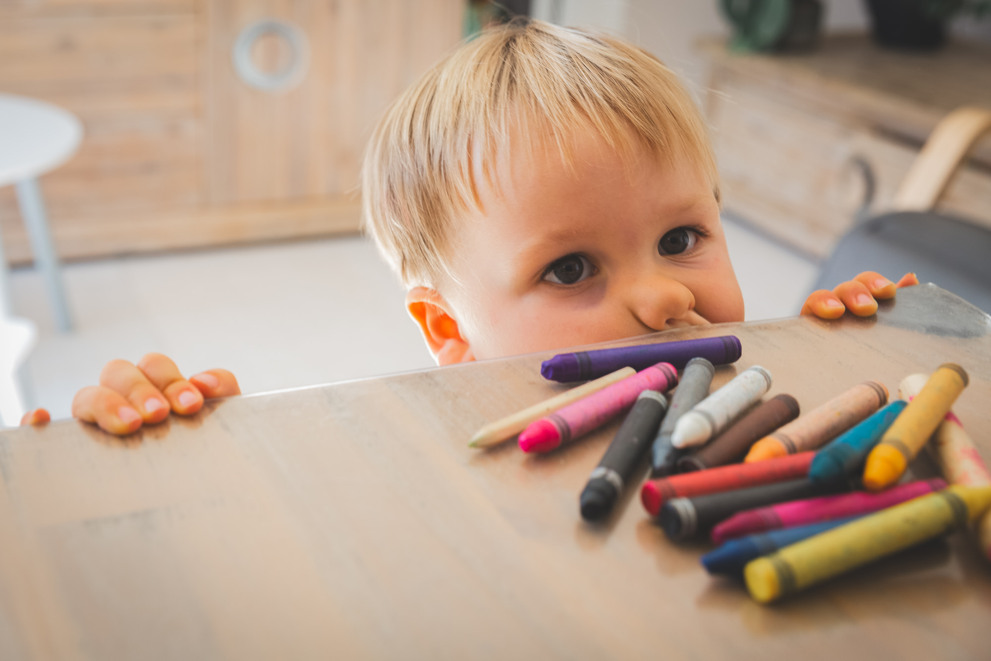 Séance photo famille à la Gaude, près de Nice : portrait d'un enfant et ses crayons de couleurs.