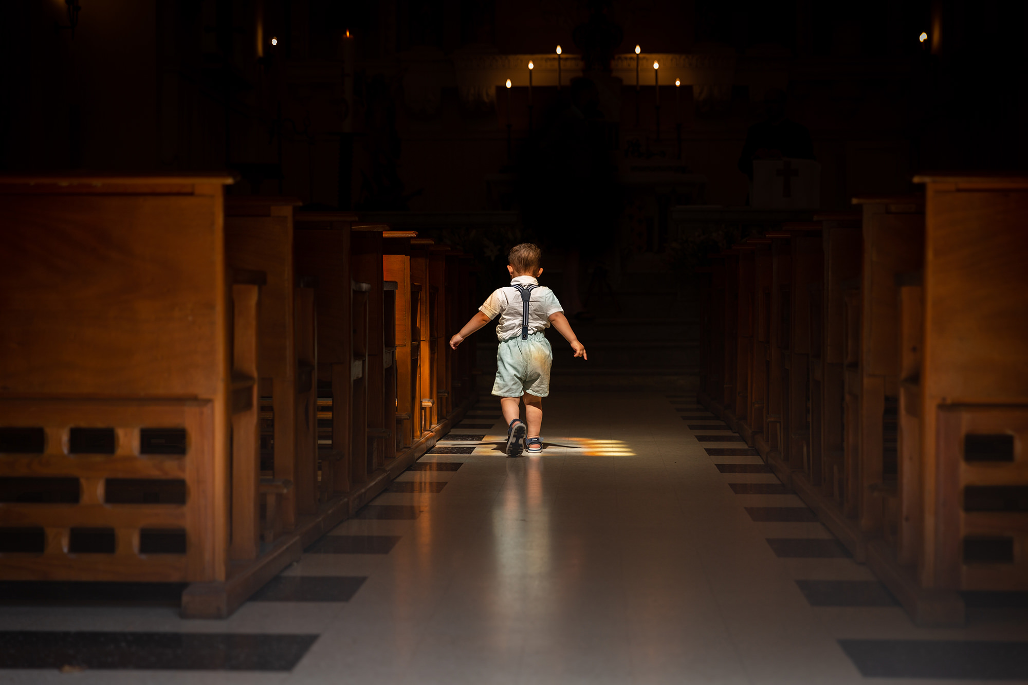 Un enfant dans une église. Reportage photo de baptême à Fayence
