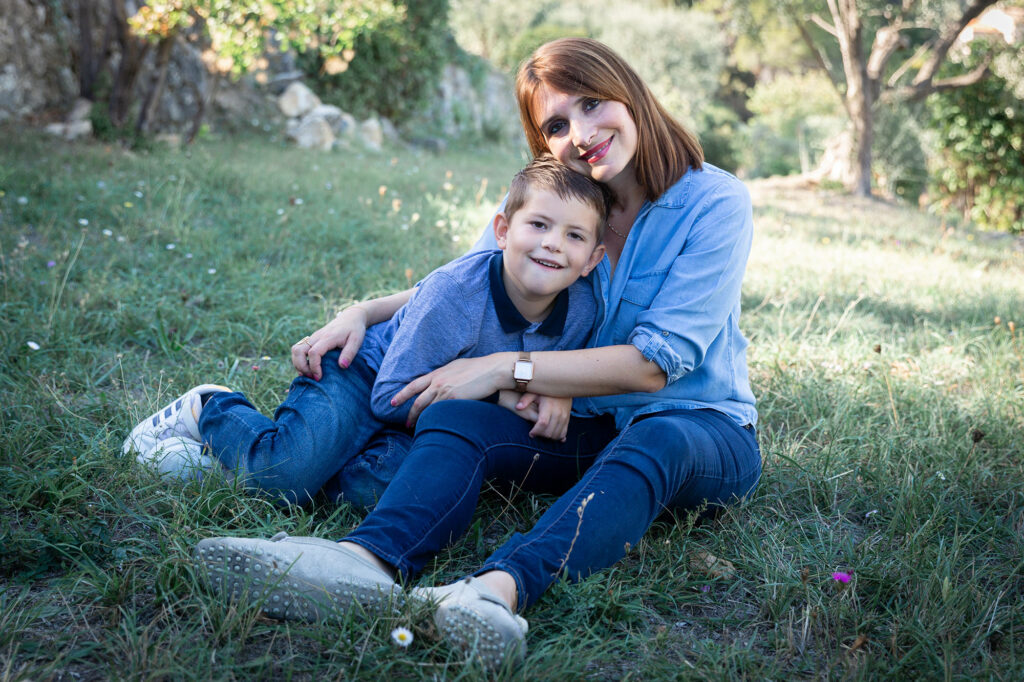 Séance photo famille à Tourrettes, Var. Une maman pose avec son fils dans un champs d'oliviers.