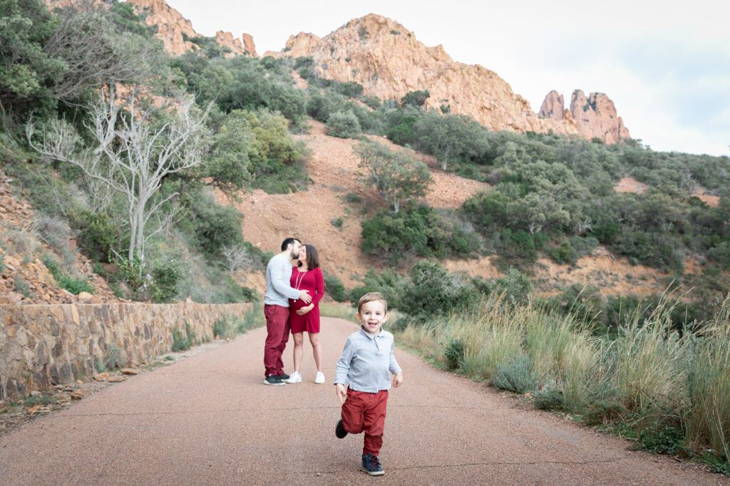 Séance photo grossesse en extérieur dans l'Esterel. Photo prise sur le vif d'un enfant et ses parents avec la maman enceinte.