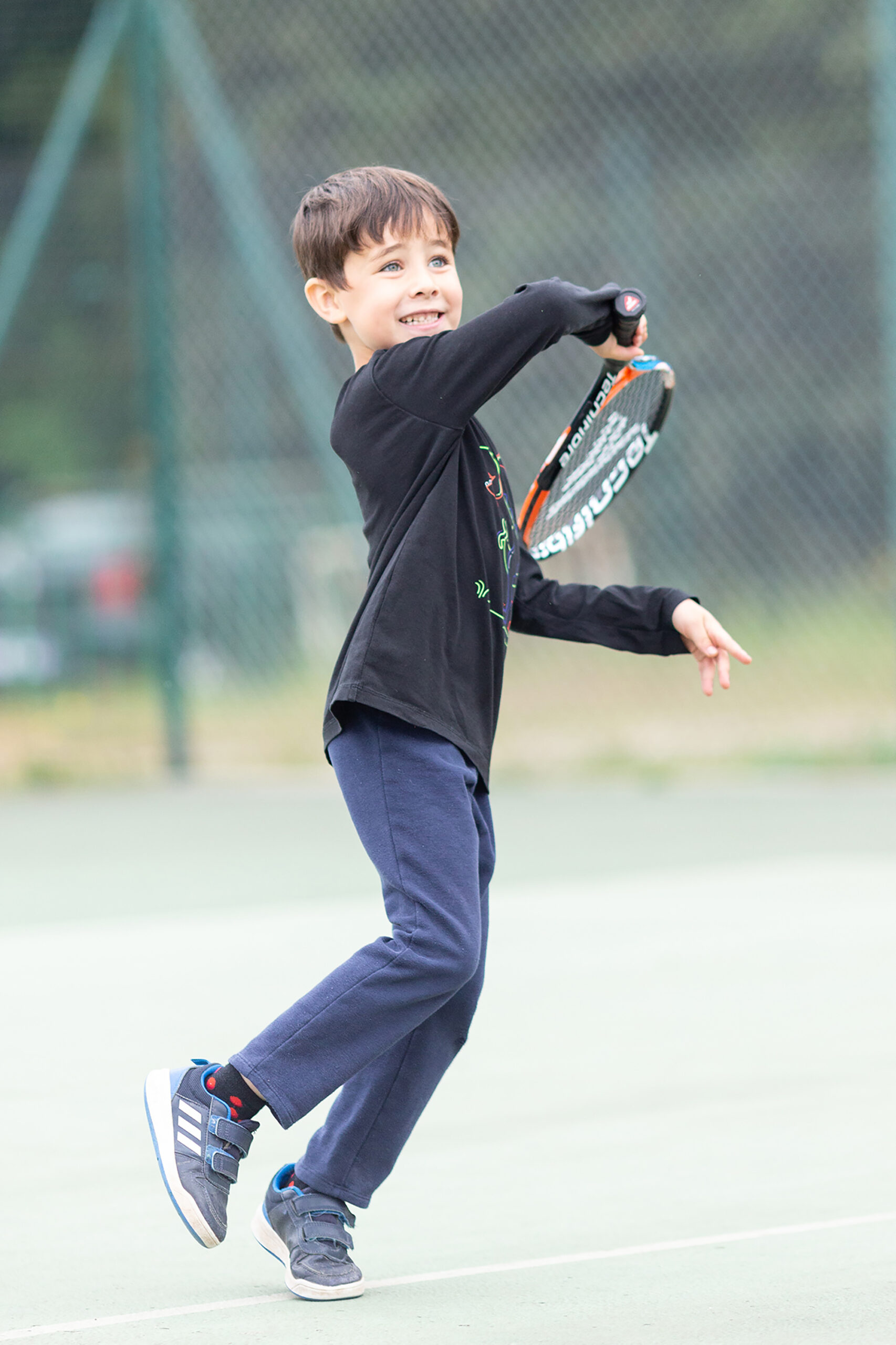 Photo prise sur le vif d'un enfant jouant au tennis à Fayence.