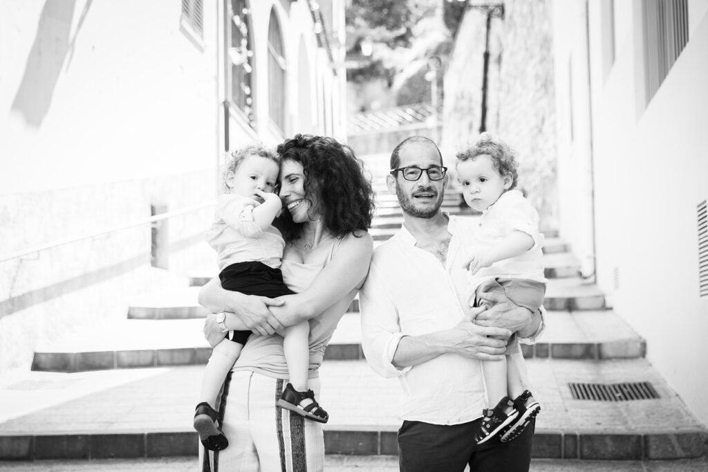 Séance photo lifestyle en famille à Nice. Portrait naturel en noir et blanc d'une famille avec le papa, la maman et les deux jumeaux de deux ans dans le Vieux-Nice.
