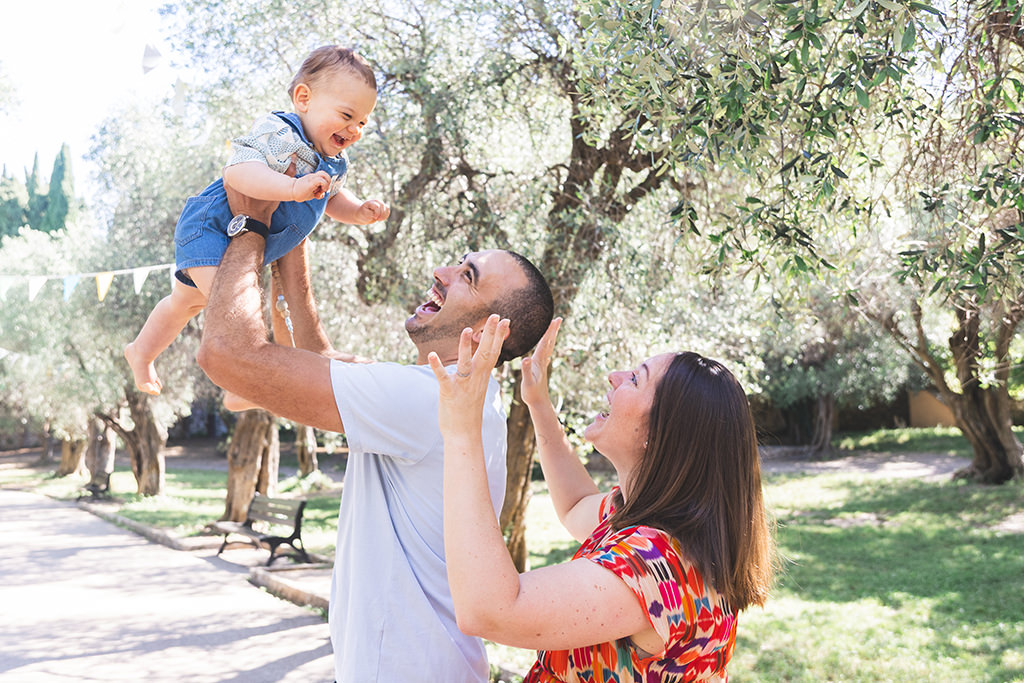 Photo prise sur le vif de deux jeunes parents jouant avec leur bébé de 18 mois
